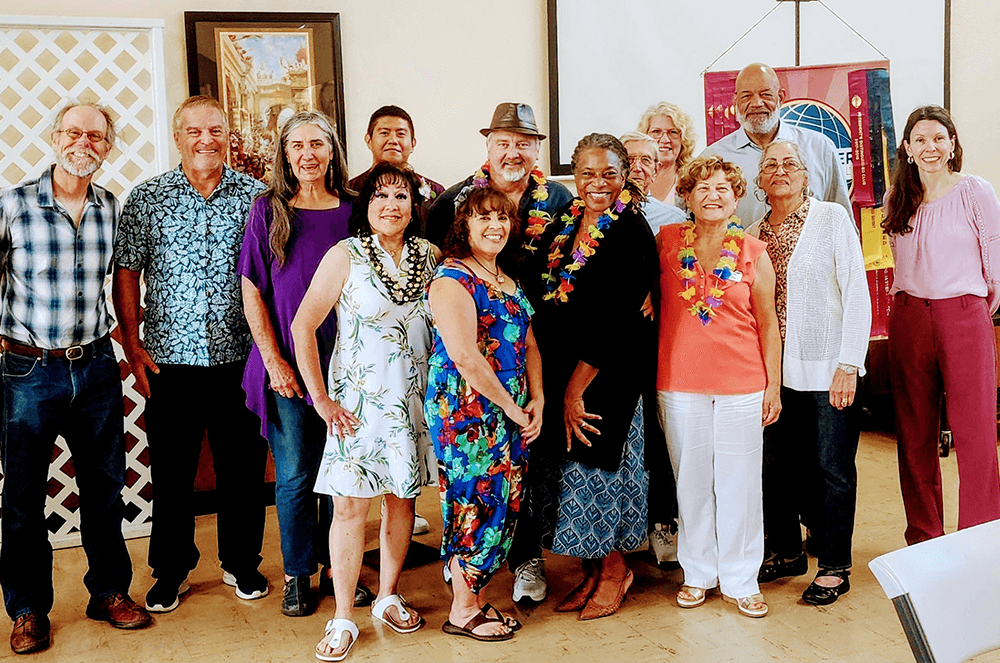 Group of people posing in Hawaiian attire and leis for wedding ceremony